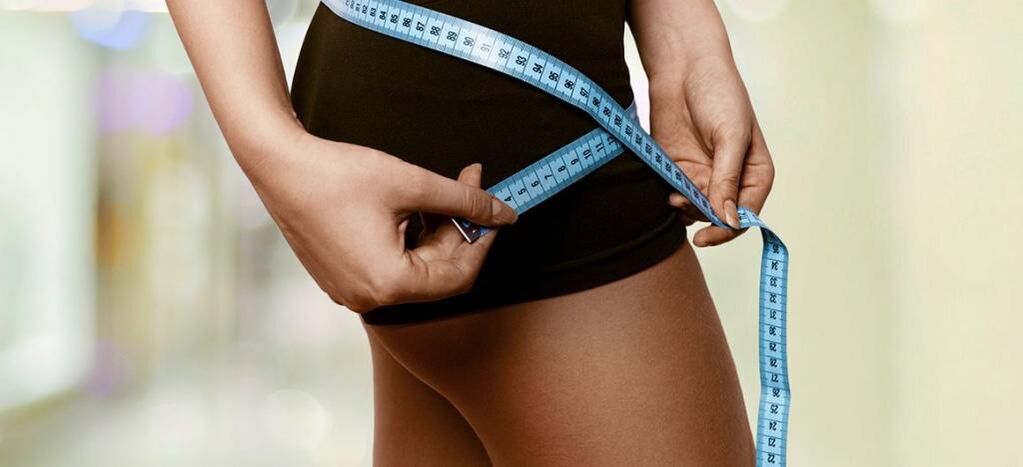 Женщина фиксирует результаты эффективного похудения